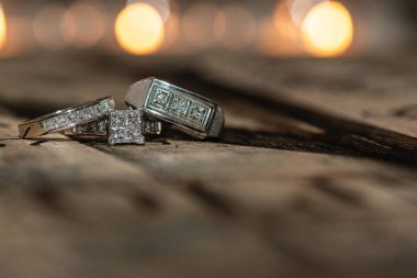 Birbiri ardına dizilmiş elmasları olan üç gümüş alyans seti.