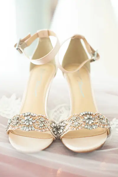 Stock image Elegant bridal shoes with rhinestones in front of bridal floral bouquet