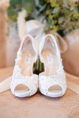 Göz kamaştırıcı beyaz, açık ayak parmaklı, naylon ayakkabılar beyaz dantelli kalp ve çiçek tasarımları yan yana.
