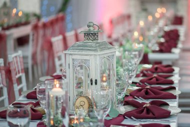 Yemek masasında muhteşem beyaz fener. Düğün töreninde kırmızı ve beyaz dekor ve yeşillik olacak.