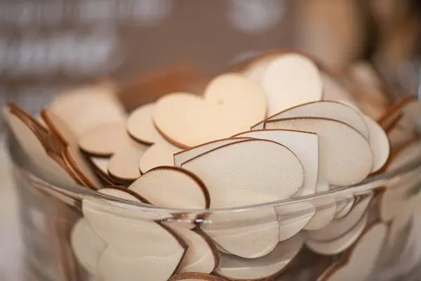 stock image Hundreds of wood chips in the shape of hearts in glass bowl used for writng messages to bride and groom with a marker at wedding reception