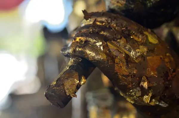 Budizm heykelinin eli şemsiyenin bir parçasını tutuyor..