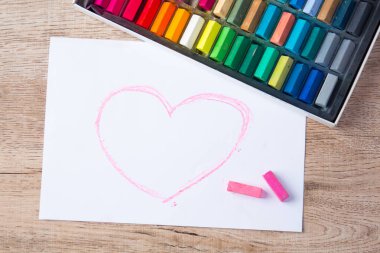 yassı kırtasiye malzemesi renk çubukları ve kağıt üzerinde pembe kalp şekli