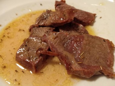 Beyaz tabakta baharatlı sığır carpaccio.