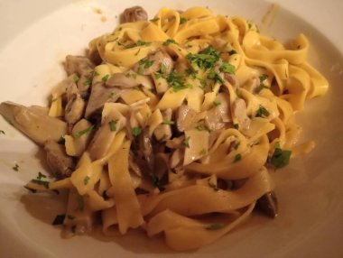 Maydanozlu beyaz bir kasede spagetti.