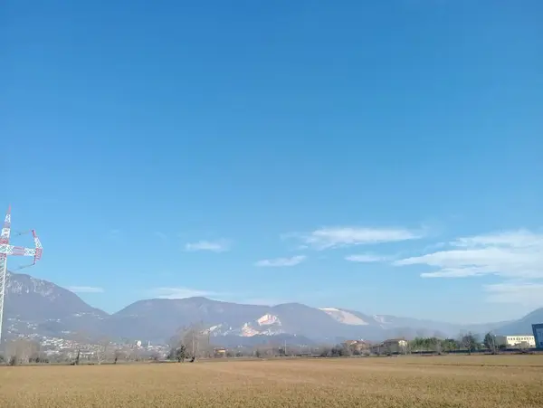 a field with a telephone tower in the distance