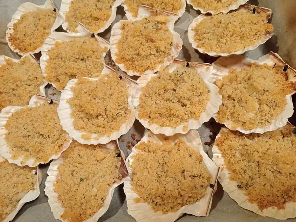 Gratin scallops are an exquisite fish appetizer! They are made with scallops in their shells; which are first covered with breadcrumbs, extra virgin olive oil, aromatic herbs and then baked