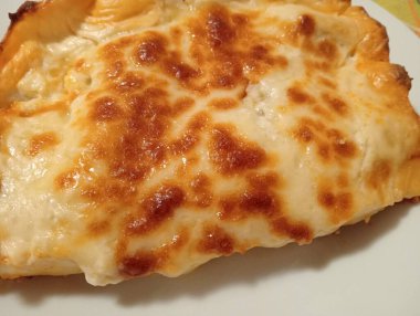 Eti kıyma ve beşameli lazanya yakın çekim. Emilian mutfağından bir çeşit yemek. Arka plan olarak İtalyan yemekleri.