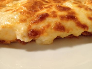 Eti kıyma ve beşameli lazanya yakın çekim. Emilian mutfağından bir çeşit yemek. Arka plan olarak İtalyan yemekleri.