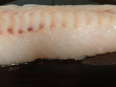 Beyaz balık siyah tavada pişiyor.