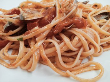 domates soslu makarna ve beyaz tabakta sarımsak.