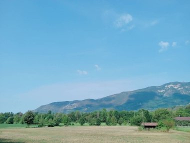 Dağları ve mavi gökyüzü olan güzel bir manzara.