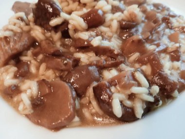 Mantarlı, peynirli ve maydanozlu bir tabak risotto.