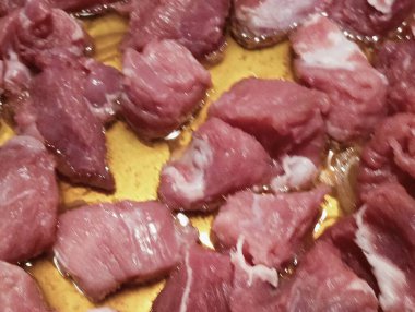 Küçük kırmızı et parçaları tavada yağla pişiriliyor.