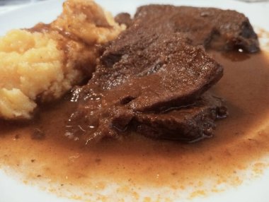 Bir dilim ağır ateşte pişmiş biftek ve polenta. Kuzey İtalya 'dan tipik Brescia mutfağı.