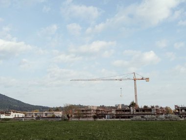 İnşaat vinçleri ve bina arka planda.