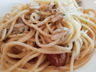 Beyaz tabakta deniz mahsullü spagetti.
