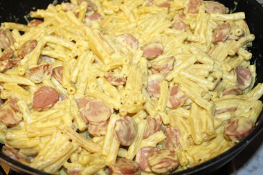 Bir kase tavuk ve tavada kızarmış yumurta ile sosis.