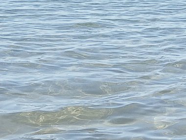 Dalgalı deniz suyu ve mavi gökyüzü