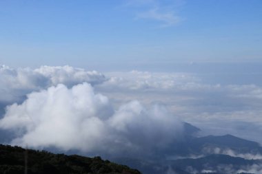 Dağlar engebeli ve beyaz bulutlar yüzüyor..