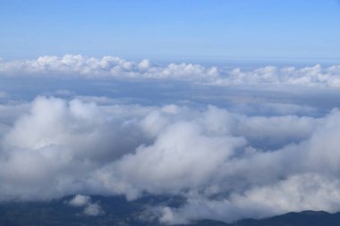 Gökyüzünde süzülen beyaz bulutlu karmaşık dağlar