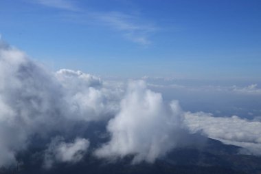 Dağların arkasında kalın beyaz bulutlar oluşuyor..