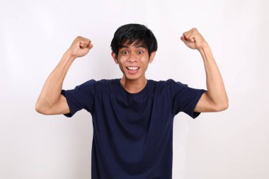 Asyalı genç adam ellerini kaldırırken ve sıkarken başarılı oldu. Beyaz arkaplanda izole