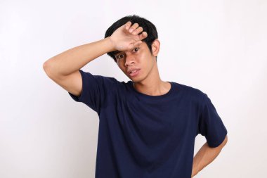 Korkak Asyalı genç adam elinde dikilirken dikiliyordu. Beyaz arkaplanda izole