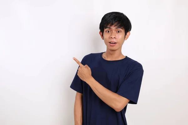 Glad Asiatisk Ung Man Stående Samtidigt Peka Och Presentera Tomt — Stockfoto