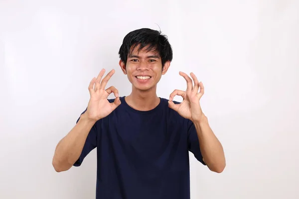 Pemuda Asia Yang Bahagia Berdiri Sambil Menunjukkan Gerakan Tangan Yang — Stok Foto