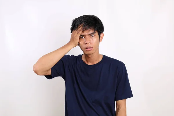 Беспокойный Азиатский Молодой Человек Стоящий Держа Голову Изолированный Белом Фоне — стоковое фото