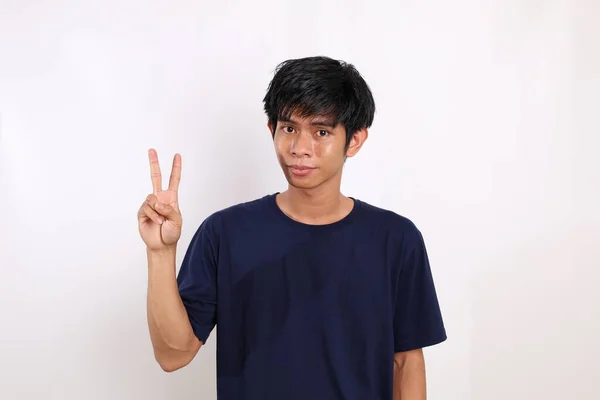 Mutlu Asyalı Genç Adam Iki Parmağını Gösterirken Ayakta Duruyor Kopyalama — Stok fotoğraf