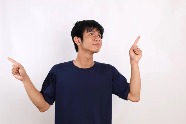 Счастливый Азиатский Молодой Человек Стоит Указывая Обе Стороны Изолированный Белом — стоковое фото