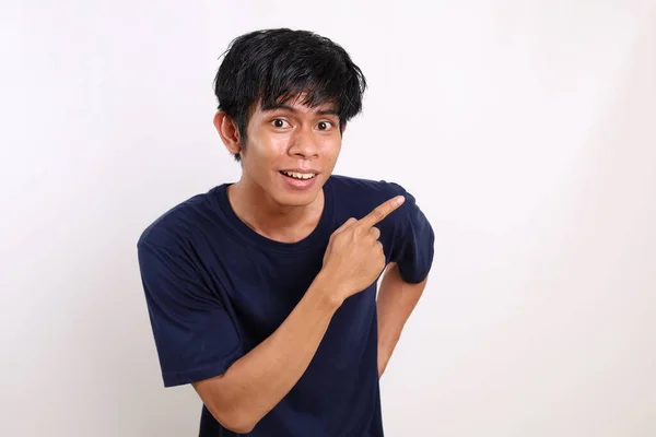 Счастливый Азиатский Молодой Человек Стоит Указывая Боком Изолированный Белом Фоне — стоковое фото
