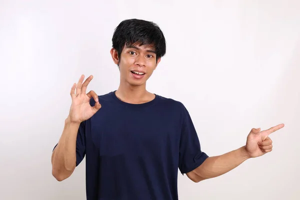 Glücklicher Asiatischer Junger Mann Der Zur Seite Zeigt Und Eine — Stockfoto