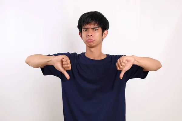 Unzufriedener Junger Asiatischer Mann Stehen Und Daumen Nach Unten Zeigend — Stockfoto