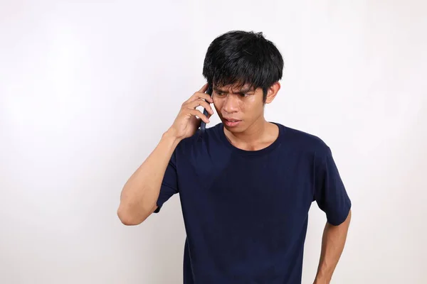 Kíváncsi Fiatal Ázsiai Férfi Alkalmi Állásban Miközben Telefonál Fehér Alapon — Stock Fotó