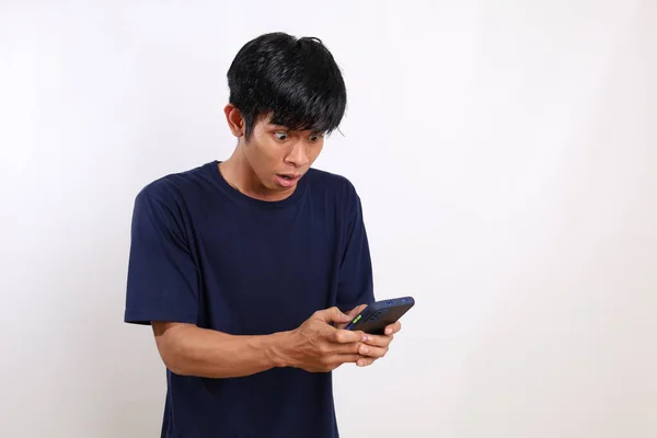 Удивлен Молодой Азиат Стоящий Держа Руках Мобильный Телефон Указывая Изолированные — стоковое фото