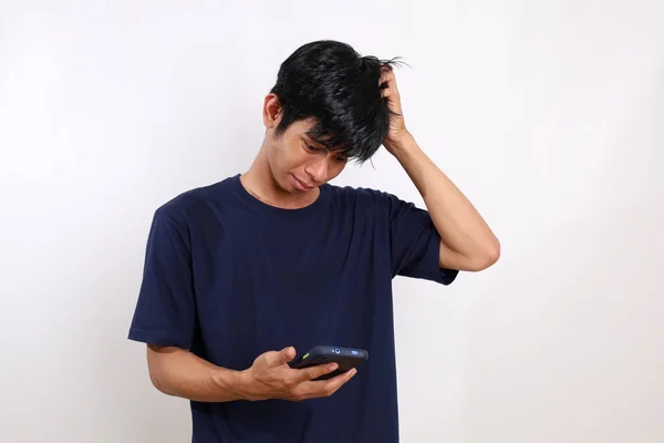 Розчарований Молодий Азіатський Чоловік Стоїть Тримаючи Голову Мобільний Телефон Ізольовані — стокове фото