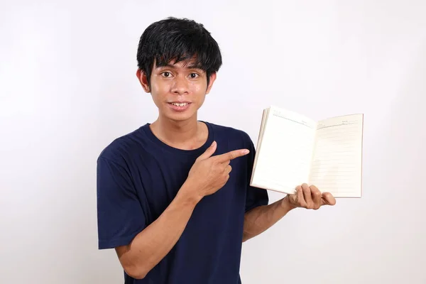 Feliz Joven Asiático Pie Mientras Presenta Libro Aislado Sobre Fondo —  Fotos de Stock