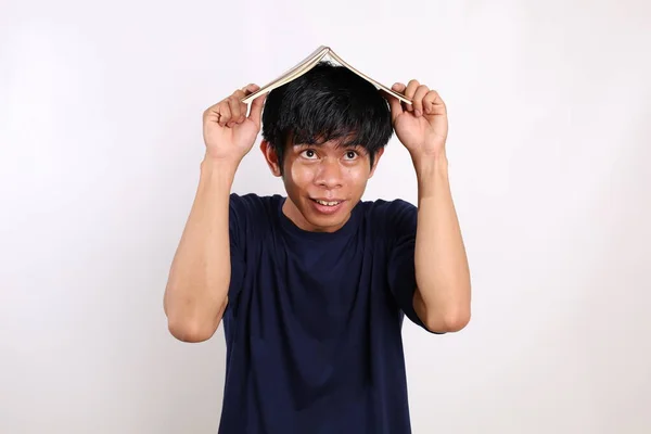 Porträtt Ung Asiatisk Man Med Bok Huvudet Isolerad Vit Bakgrund — Stockfoto