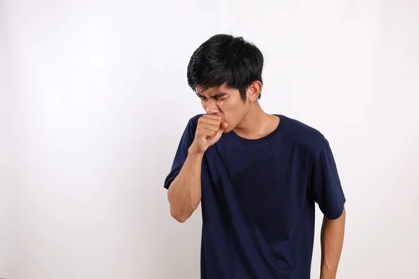 年轻的亚洲人在不经意地咳嗽在他的拳头 在白色背景上与版权保护隔离 — 图库照片