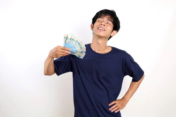 Счастливый Молодой Азиат Стоит Держа Индонезийские Банкноты Виляя Ими Изолированные — стоковое фото