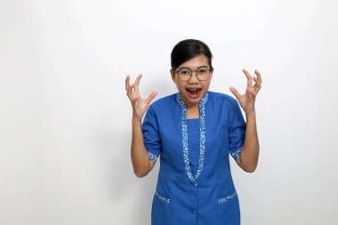 Kızgın ve hayal kırıklığına uğramış Asyalı genç bir çalışan çığlık atarken ayakta duruyor. Kopyalama alanı ile beyaza izole edilmiş