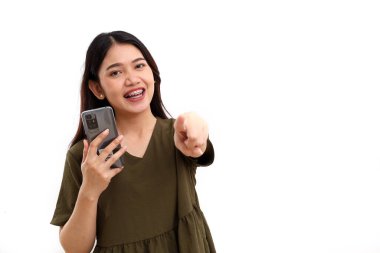 Cep telefonu tutan ve kameraya bakan mutlu genç Asyalı kadın. Beyazda izole edilmiş