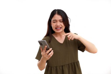 Cep telefonuyla Asyalı kızgın genç bir kadın. Kopyalama alanı ile beyaz arkaplanda izole