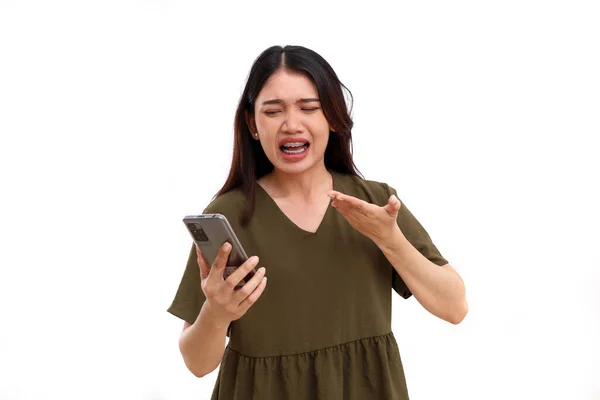 stock image Angry young asian woman while talking on the phone. Isolated on white background with copyspace