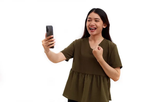 携帯電話を持ちながら立っている幸せな若いアジア人女性 いいニュースだ 白地に隔離された — ストック写真