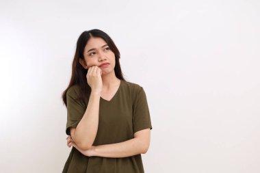 Bir şey düşünürken ayakta duran Asyalı genç kadının hüzünlü ve kasvetli ifadesi. Beyaz arkaplanda izole