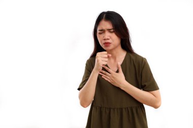 Güzel genç Asyalı kadın öksürürken ve göğsünü tutarken ayakta duruyor. Kopyalama alanı ile beyaza izole edilmiş